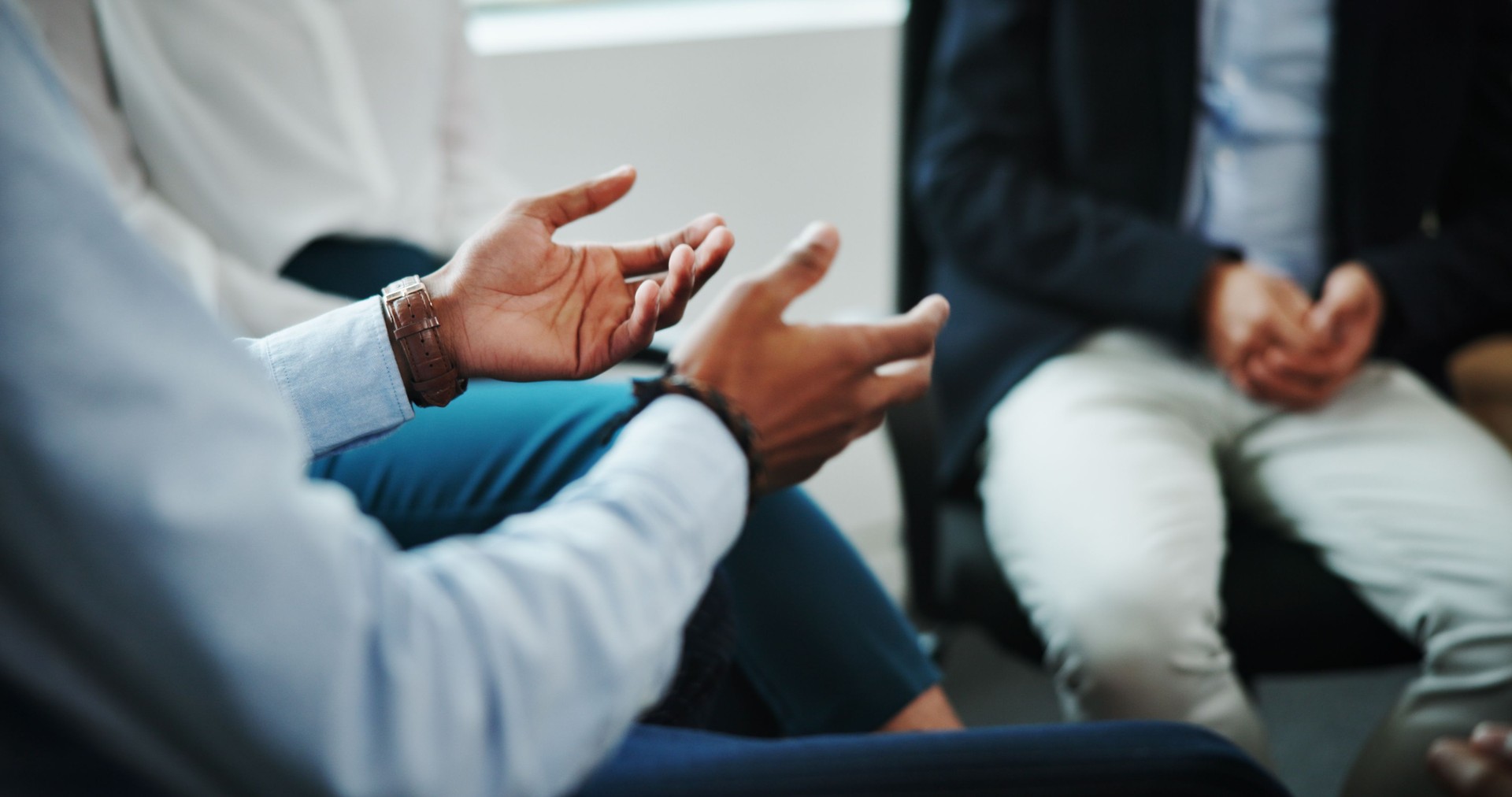 Business people, hands and discussion with support group in meeting for counseling session at office. Employees, colleagues or talking with therapist for rehabilitation or team social at workplace